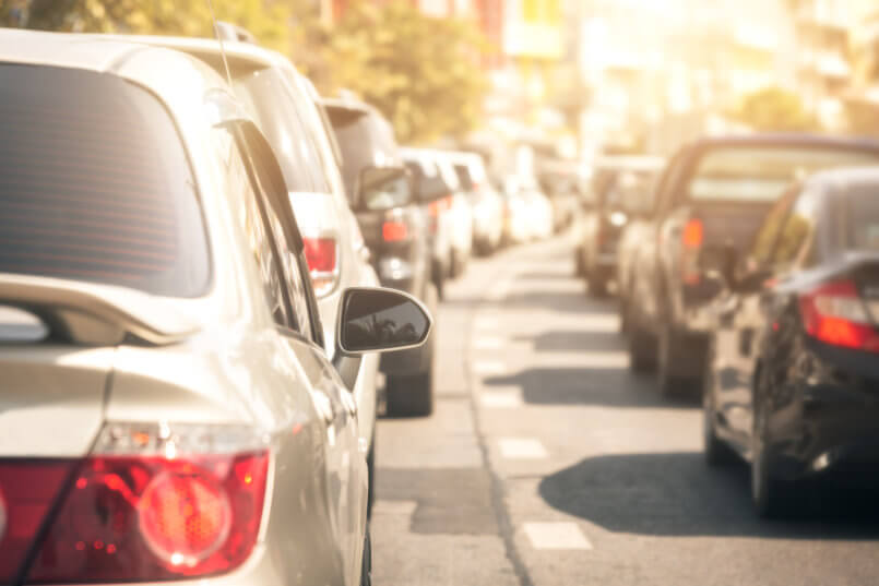 Imagem de carros no trânsito e motoristas pensando em qual bateria comprar