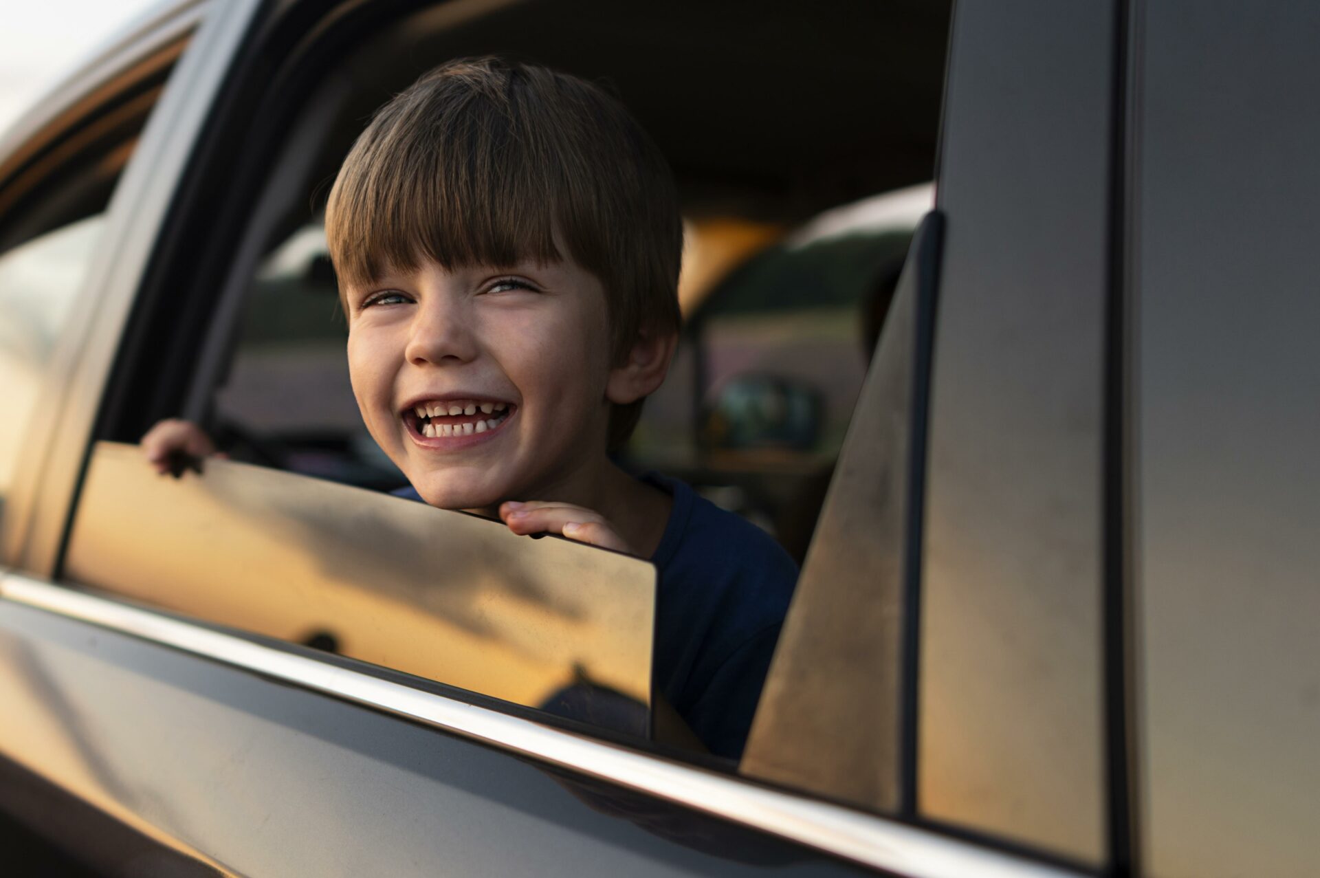 Imagem de um garoto sorrindo através da janela de um carro que possui certificado de garantia Moura