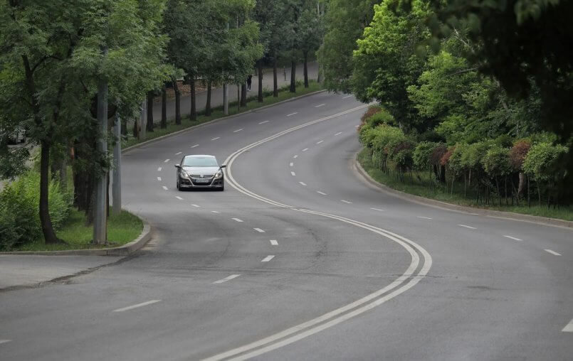 Imagem de carro cinza sozinho em uma estrada