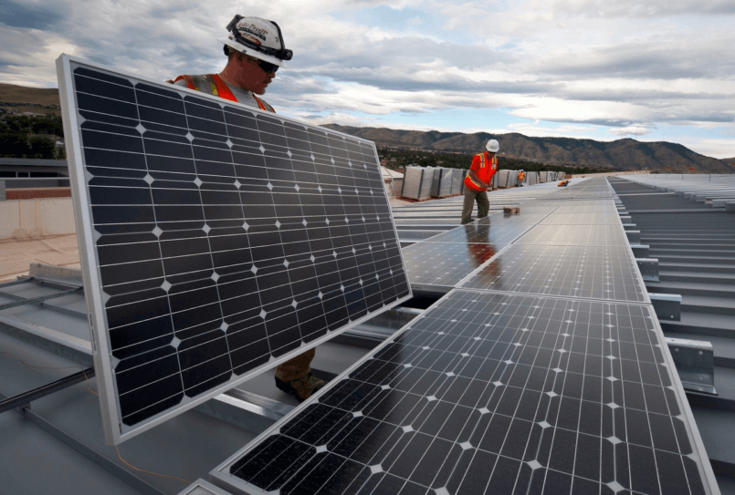 Imagem de um homem segurando um painel sabendo como funciona a energia solar