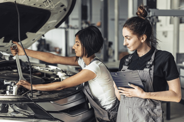 Imagem de duas especialistas checando as dicas automotivas e realizando reparos no veículo