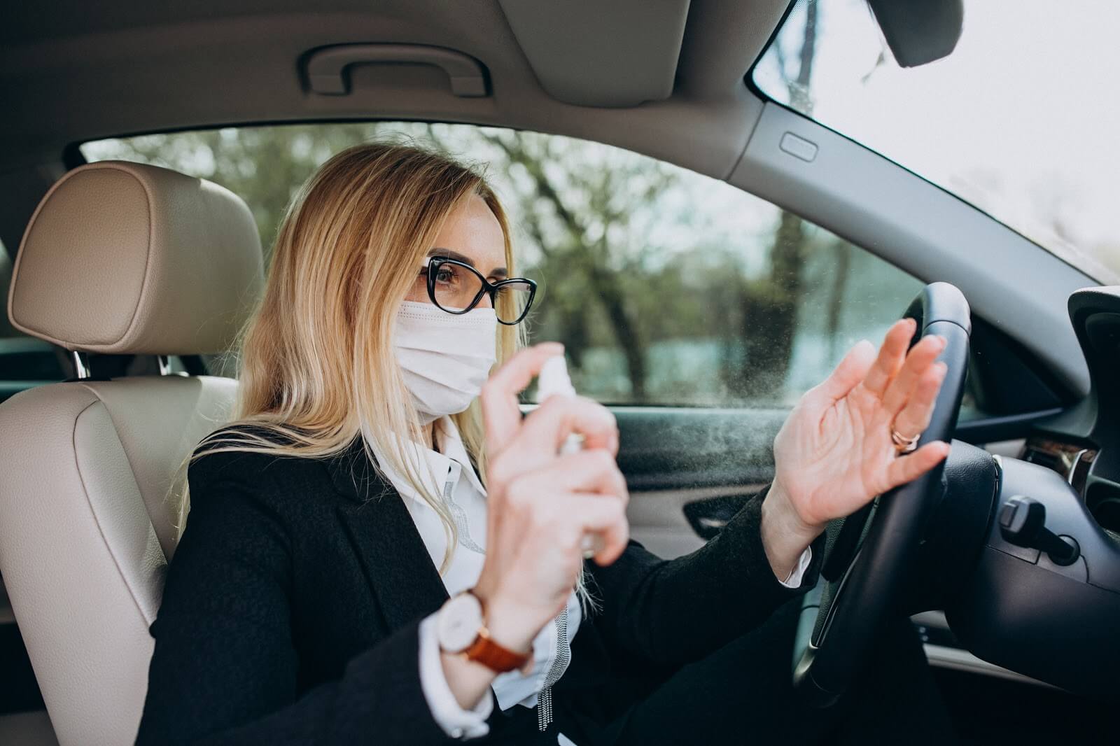 Imagem de uma mulher higienizando as mãos após sair de carro na quarentena