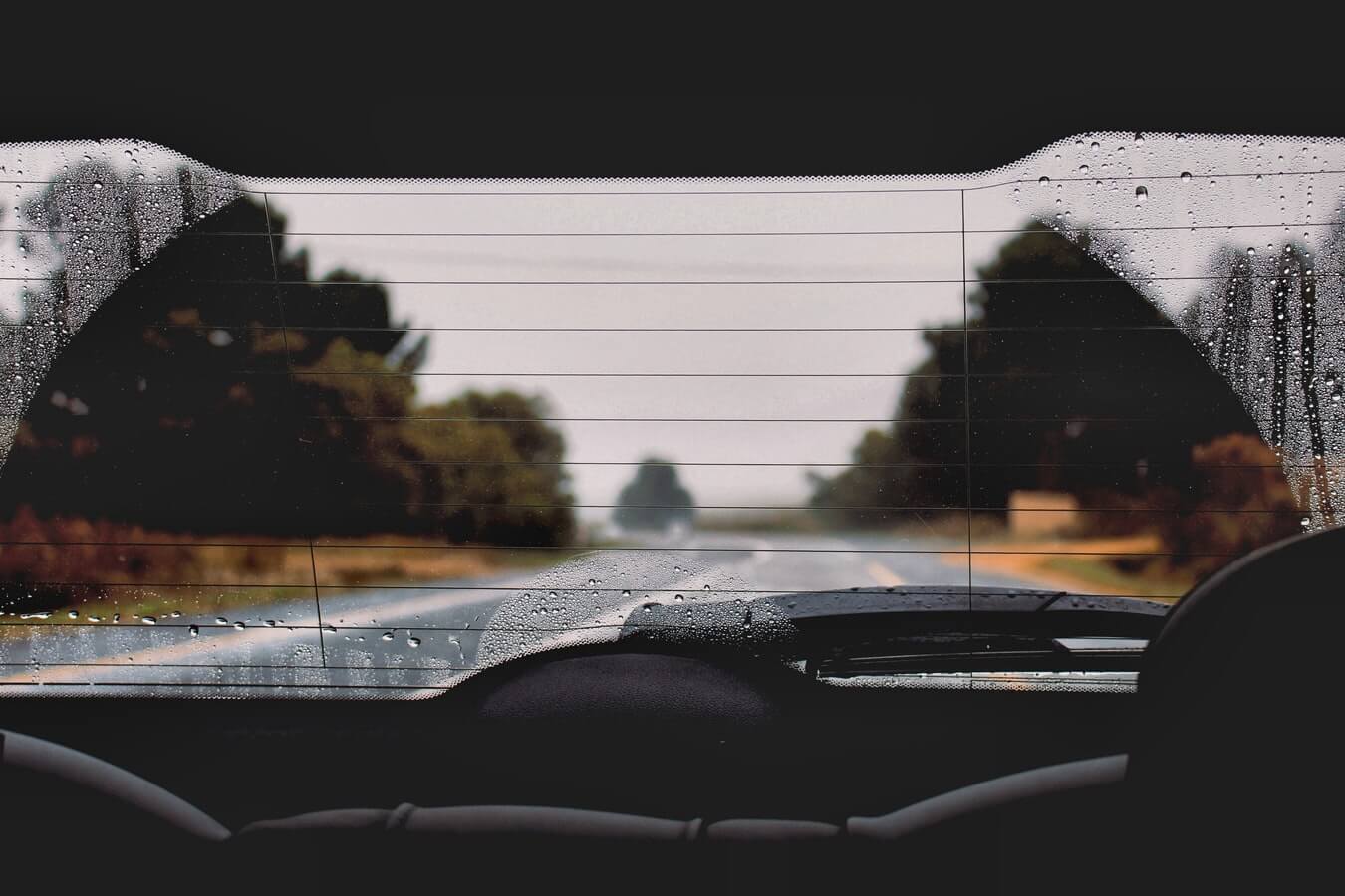 Vidro traseiro de um carro embaçado. Uma estrada através do vidro
