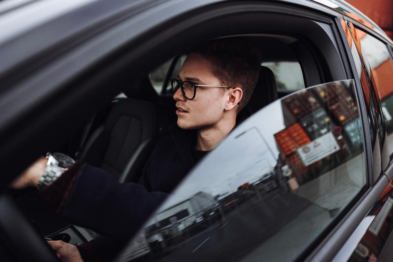 Homem de óculos dentro de um carro