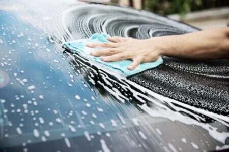 pessoa lavando o vidro do carro